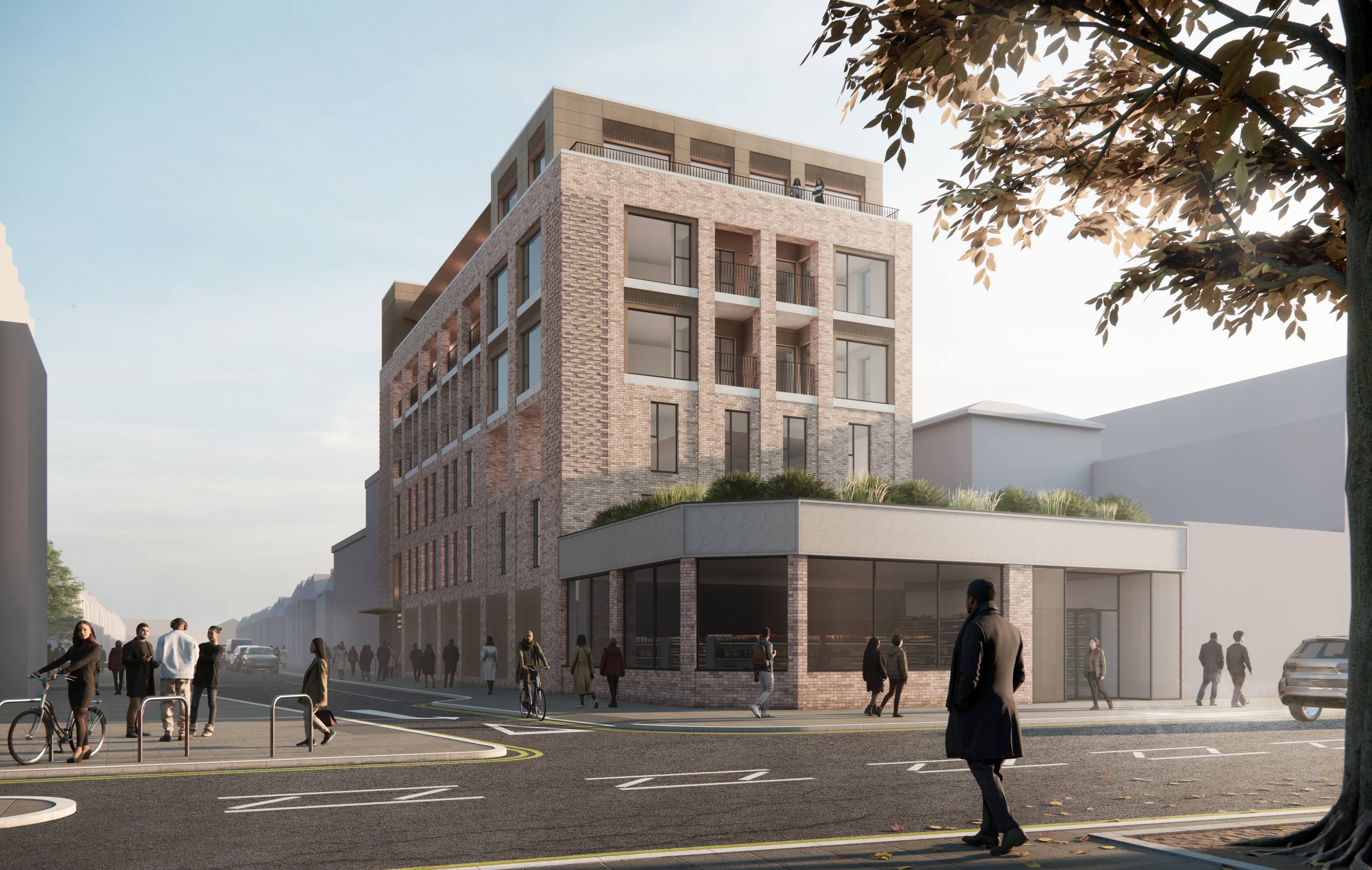 Visualisation of the scheme on its corner site, brick upper floors with balconies above a curved ground floor with a green roof