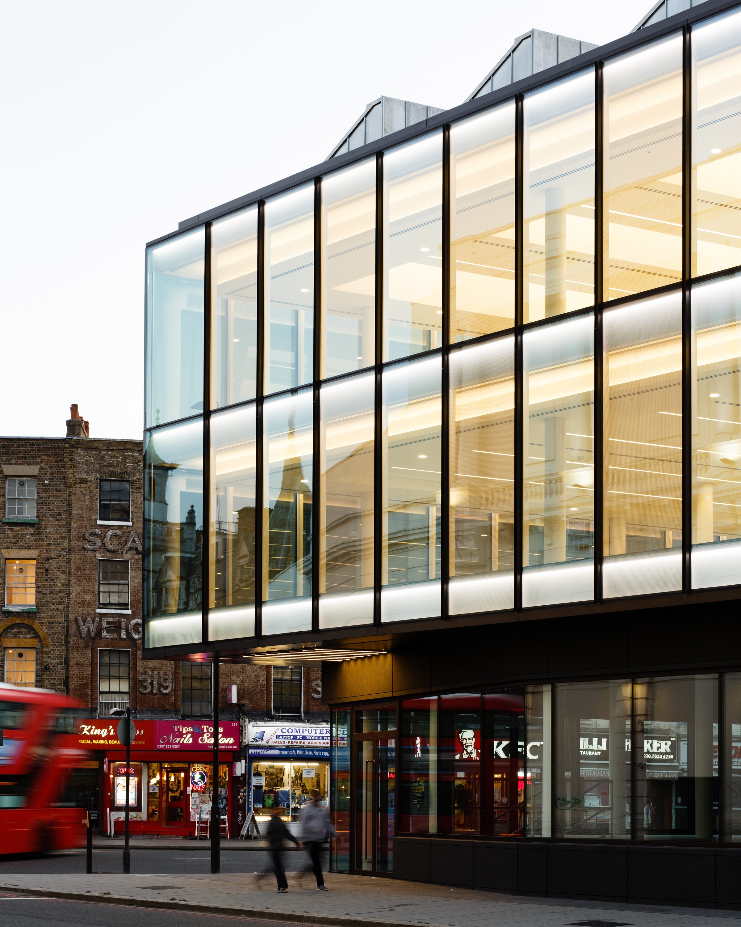 The two glazed floors cantilevered above the shopfronts, alongside the neighbouring Victorian brick terrace