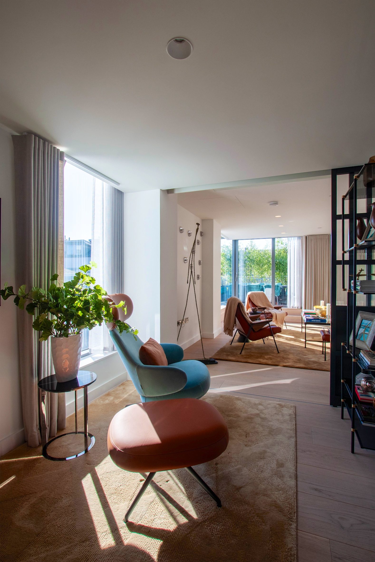 Seating area opening through to a second living space, with the terrace glazing beyond