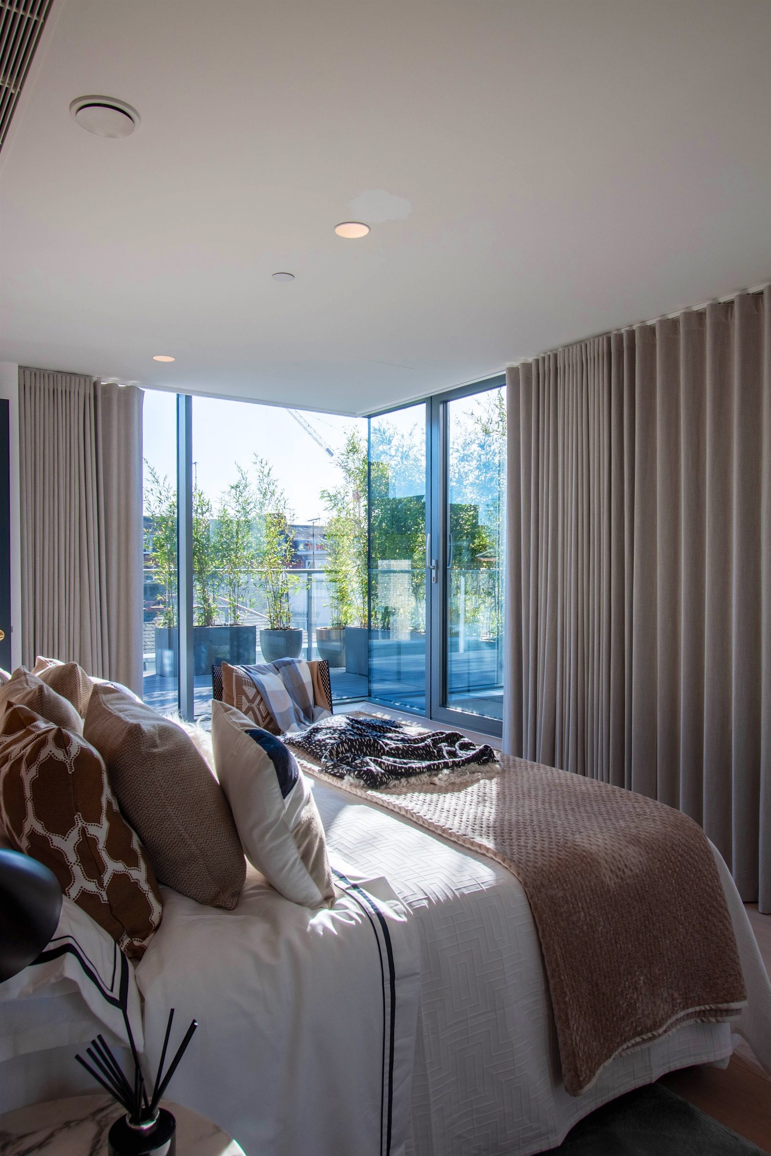 Bedroom with corner glazing looking out onto the planted terrace