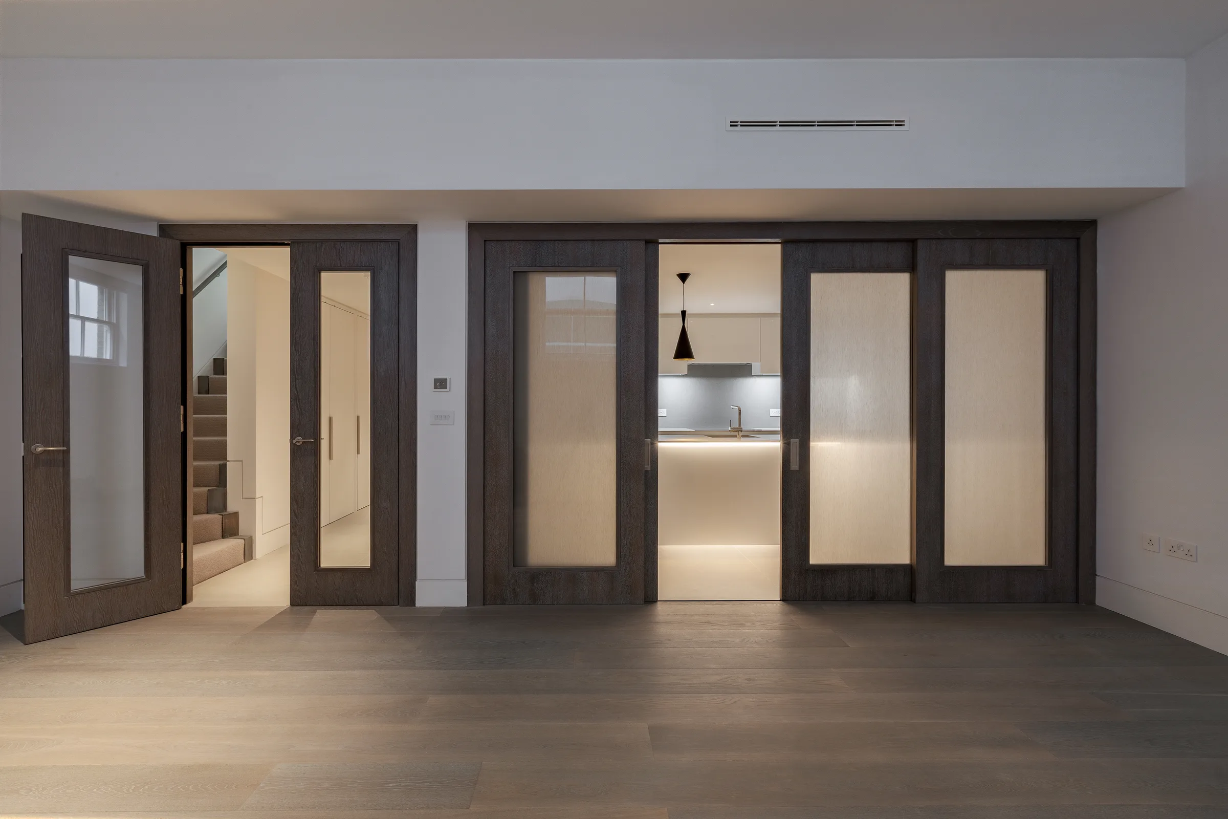 Glazed timber doors opening from the hall through to the kitchen, with the stair beyond