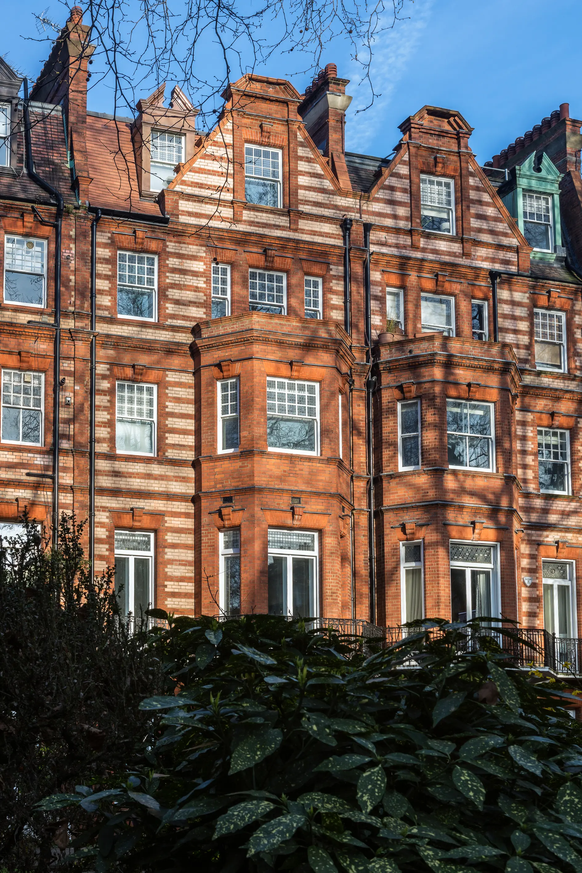 The red brick mansion block frontage, with canted bay windows and gabled dormers above