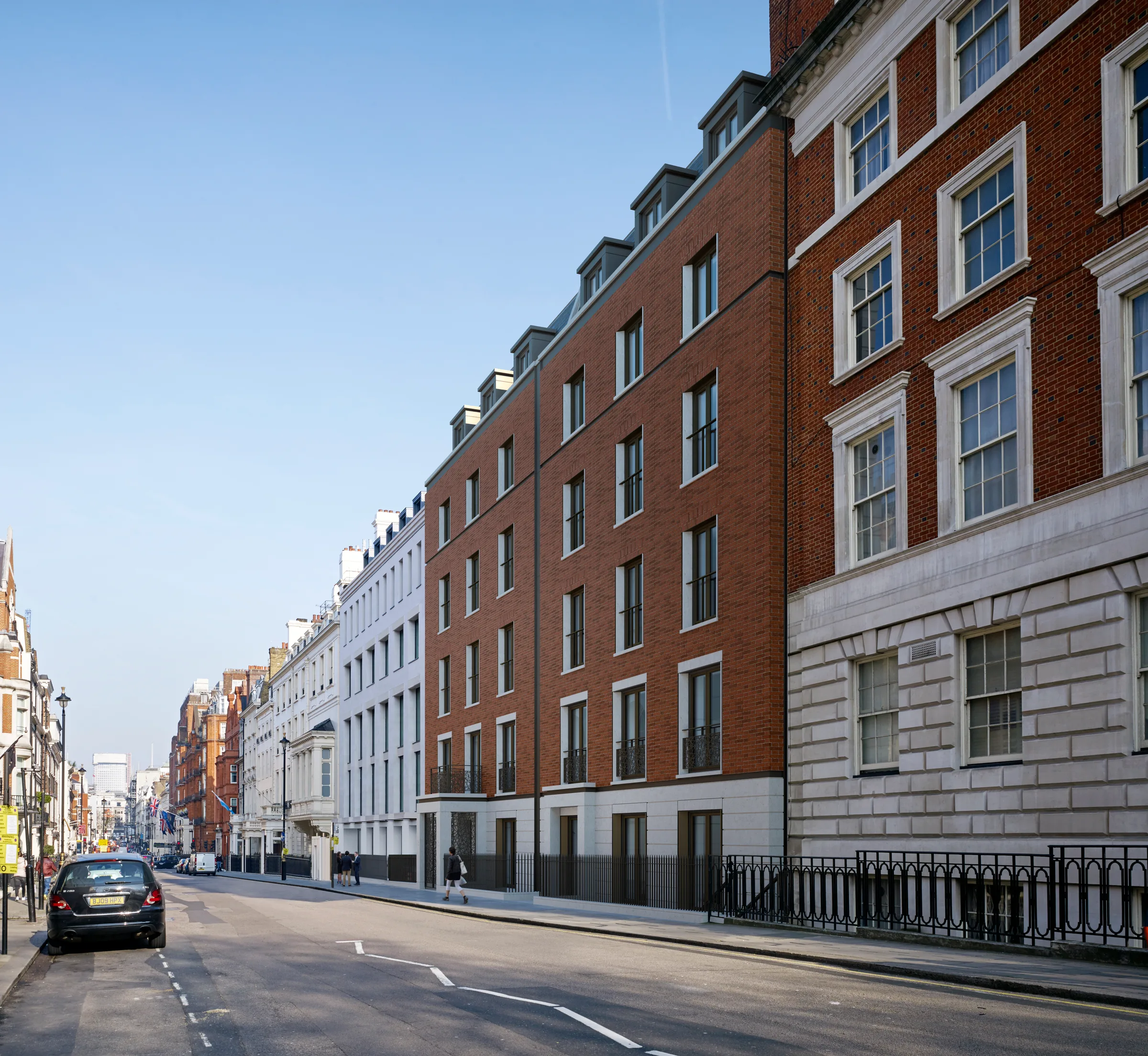 Visualisation of the building along the street, its red brick frontage between neighbouring stucco and brick facades